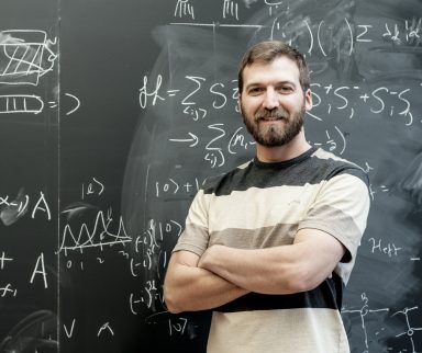 Man standing in front of a blackboard of equations