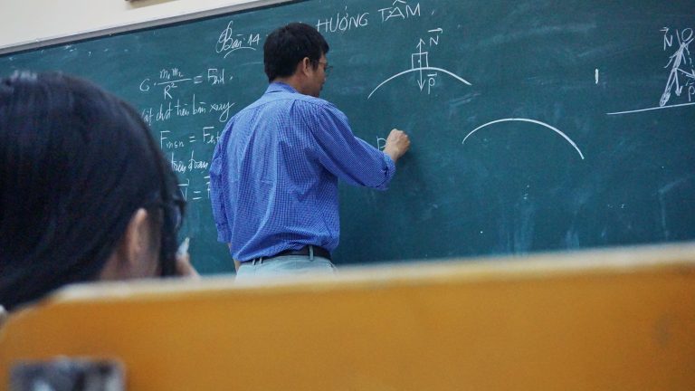 Teacher writing on chalkboard